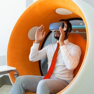 Excited serious professional using VR glasses for project developing. Man wearing virtual reality headset, touching air, gesturing. Interactive technology concept