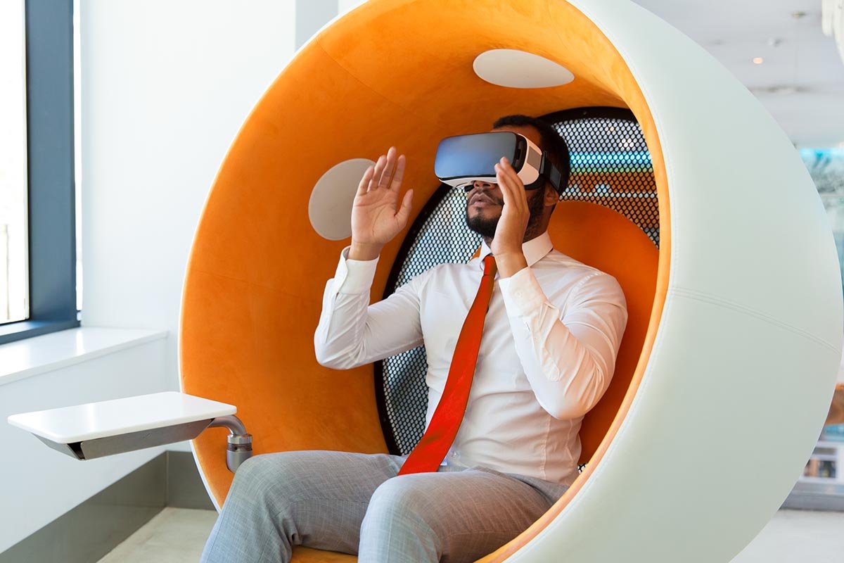 Excited serious professional using VR glasses for project developing. Man wearing virtual reality headset, touching air, gesturing. Interactive technology concept